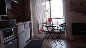 a kitchen with a table and chairs in front of a window at Studio meublé vue tour Eiffel et tout Paris in Saint-Maurice +2 photos