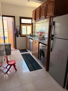 a kitchen with a refrigerator and a red chair at Entire Ocean-View Apartment in Rabat