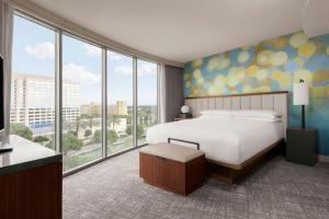 a hotel room with a bed and large windows at Anaheim Marriott Suites in Anaheim +26 photos