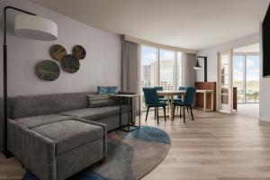 a living room with a couch and a table with chairs at Anaheim Marriott Suites in Anaheim