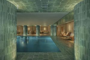 a swimming pool in a building with columns at The Lake Como EDITION in Griante Cadenabbia