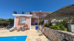 a villa with a swimming pool and a house at Moulinos Cottages Kefalonia in Kardhakáta