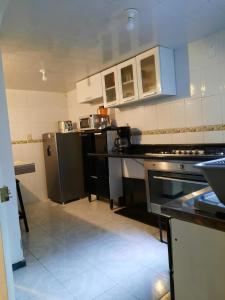 a kitchen with black and white appliances in it at Casa del Parque en Toluca in Toluca