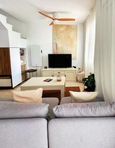a living room with a couch and a tv at Limon Home in Benacazón