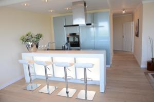 eine Küche mit einer weißen Theke und Stühlen in der Unterkunft Luxury apartment in Düsseldorf near trade fair in Düsseldorf + 10 Fotos