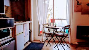 a kitchen with a table and chairs and a window at Studio meublé vue tour Eiffel et tout Paris in Saint-Maurice