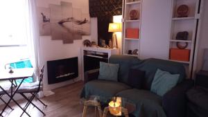 a living room with a couch and a fireplace at Studio meublé vue tour Eiffel et tout Paris in Saint-Maurice