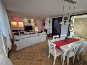a kitchen and living room with a table and chairs at Dom pod flagą in Sobącz