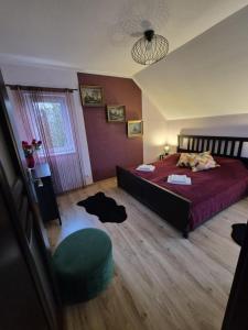 a bedroom with a red bed and a green chair at Dom pod flagą in Sobącz +36 photos