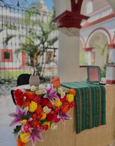 a table with a bunch of flowers next to a table with a laptop at Casa santo benito in Atlixco