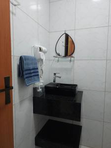 a bathroom with a black sink and a mirror at Maria Bonita Apartment | Cozy, 10 minutes from the city center in Caruaru +13 photos