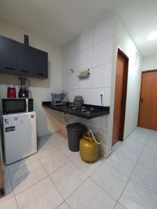 a kitchen with a counter and a refrigerator at Maria Bonita Apartment | Cozy, 10 minutes from the city center in Caruaru