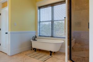 a bath tub in a bathroom with a window at Purple Parrot - 200 Lenora Ct in Dauphin Island