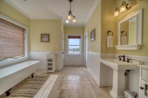 a bathroom with a tub and a sink at Purple Parrot - 200 Lenora Ct in Dauphin Island
