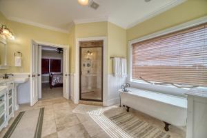a large bathroom with a tub and a shower at Purple Parrot - 200 Lenora Ct in Dauphin Island