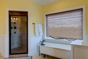 a bathroom with a tub and a shower with a window at Purple Parrot - 200 Lenora Ct in Dauphin Island +62 photos