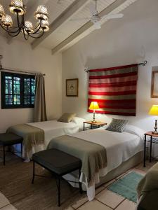 two beds in a room with two tables and lamps at Chañarmuyo Casa de Huéspedes in Chañarmuyo +44 photos