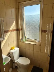 a bathroom with a white toilet and a window at Hostel Arkobaleno sieci Mazowia Hostels Group in Marki +24 photos