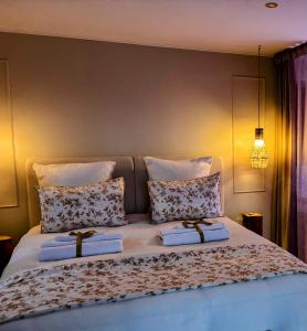a bedroom with a large bed with two pillows at L'instant Beaujolais 2 ou 4 personnes Logis cosy balnéo vue jardin in Theizé