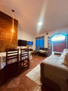 a living room with a bed and a brick wall at Lar Doce Estadia in São Pedro da Aldeia