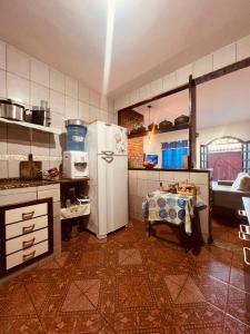 a kitchen with a refrigerator and a table in it at Lar Doce Estadia in São Pedro da Aldeia