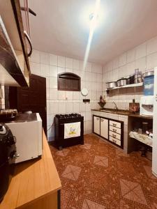 a kitchen with a stove in the middle of it at Lar Doce Estadia in São Pedro da Aldeia +11 photos