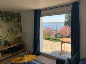 a living room with a large sliding glass door at Confortable appartement vue lac de Pareloup in Arvieu