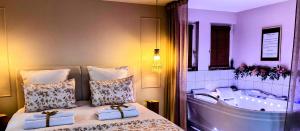 a bedroom with a tub and a bed with two towels at L'instant Beaujolais 2 ou 4 personnes Logis cosy balnéo vue jardin in Theizé