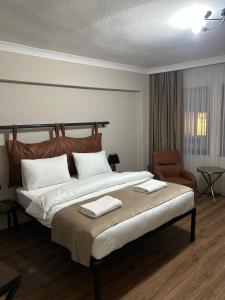 a bedroom with a large bed and a chair at Pera Line Yalova in Yalova