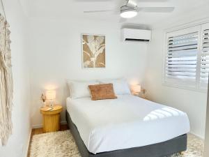 a small bedroom with a white bed and a window at Ballina Oasis in Ballina