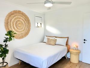 a bedroom with a bed with white sheets and a plant at Ballina Oasis in Ballina +27 photos