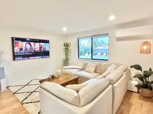 a living room with a white couch and a tv at Ballina Oasis in Ballina
