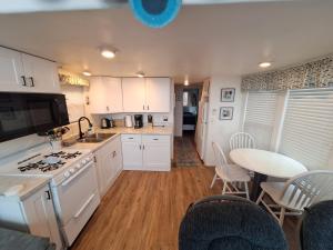 a kitchen with white cabinets and a table with chairs at Oceanfront Cabin 4 with Jacuzzi Pet Friendly in Smith River