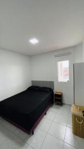 a bedroom with a black bed and a window at Vitallino Apartment | Modern with A/C, 10 min from the City Center in Caruaru