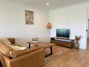 a living room with a couch and a television at Ballina Oasis in Ballina