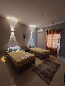 a bedroom with two beds and a rug at El Agamy Hotel Apartment in Luxor +9 photos