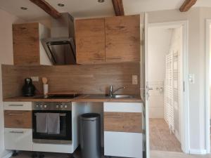 a kitchen with wooden cabinets and a sink at Lewitz-Urlaub in Lübesse