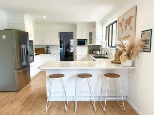 a kitchen with a large white island with two bar stools at Ballina Oasis in Ballina