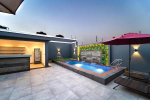 a backyard with a swimming pool and an umbrella at One90 Apartment in Lagos