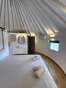 una camera da letto con un letto su cui sono appoggiati due asciugamani di Apostolis Windmill a Psarou Altre 84 foto