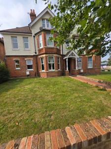 a brick house with a lawn in front of it at Aura - 8ight Havens in Folkestone