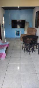 a living room with a table and chairs and a tv at Pousada Mosselini in São Gabriel