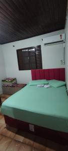 a large bed in a room with red and white walls at Pousada Mosselini in São Gabriel