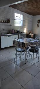 a kitchen with a table and chairs in a room at Pousada Mosselini in São Gabriel