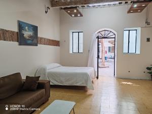 a living room with a bed and a couch at Hostalgia Casa Zul in Puebla +91 photos