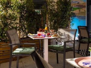 a table and chairs with food and drinks on a patio at Novotel Suites Marseille Centre Euromed in Marseille