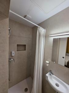 a bathroom with a shower curtain and a sink at Hotel de France in Brussels