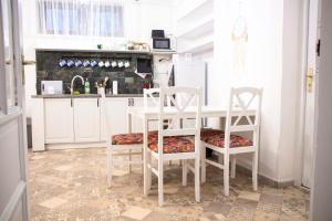 a kitchen with a white table and two chairs at Bázis Vendégház Hajdúnánás in Hajdúnánás