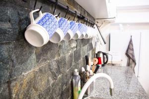 a row of coffee mugs hanging on a wall at Bázis Vendégház Hajdúnánás in Hajdúnánás +17 photos