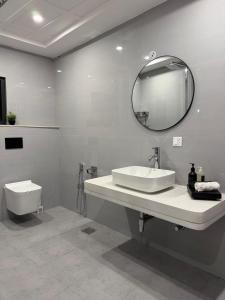 a bathroom with a sink and a toilet and a mirror at Serenity Residence Room Studio 1BHK in Rachiāl